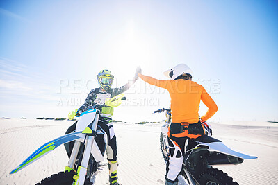 Buy stock photo Extreme sport, motorcycle and desert with high five for achievement, skill and teamwork with success. Biker, sunshine and sand with adrenaline, fitness and congratulations for speed with training