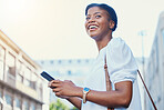 Phone, happy and young woman in the city networking on social media, mobile app or the internet. Smile, technology and African female person scroll on cellphone and walking in urban town street.