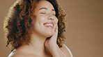 Face of happy woman, natural beauty mockup space or cosmetics for wellness in studio with smile. Skin glow, pride or confident biracial female model with skincare results isolated on brown background