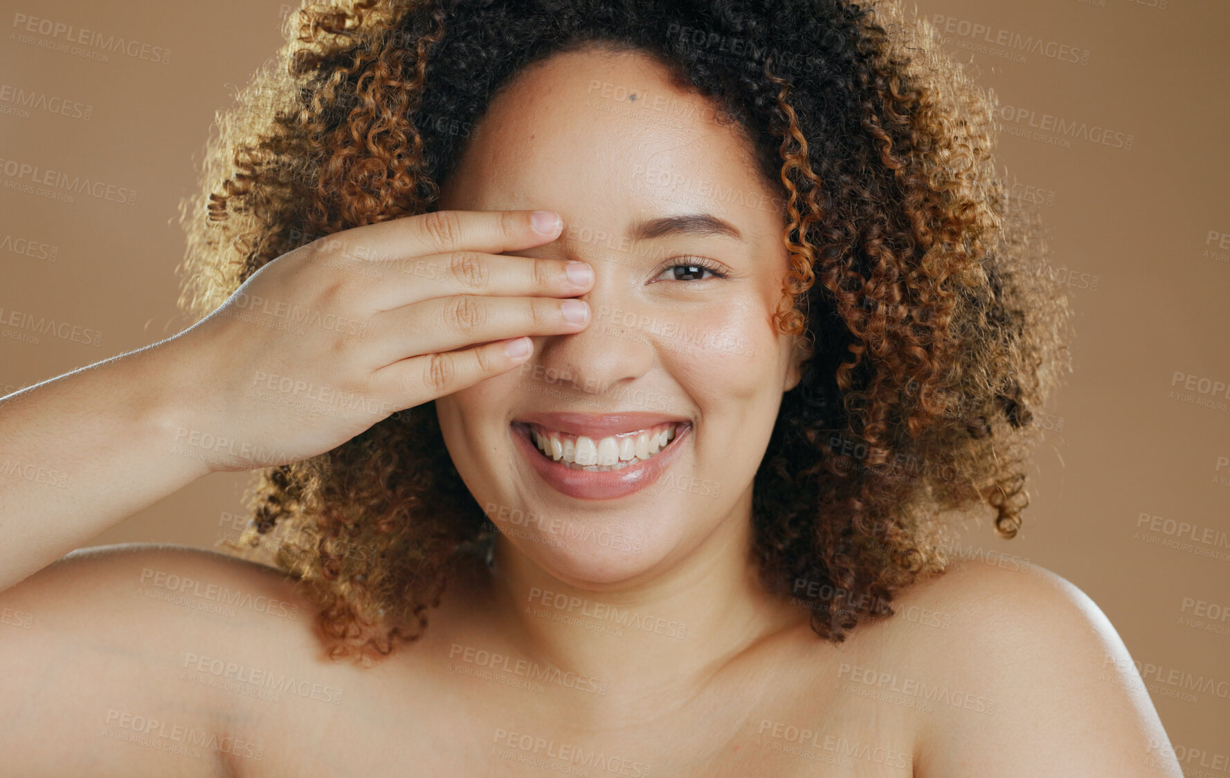 Buy stock photo Portrait, funny or happy woman with natural beauty dermatology for wellness in studio with smile. Hand, eye cover or biracial female person laughing with skincare, pride or glow on brown background