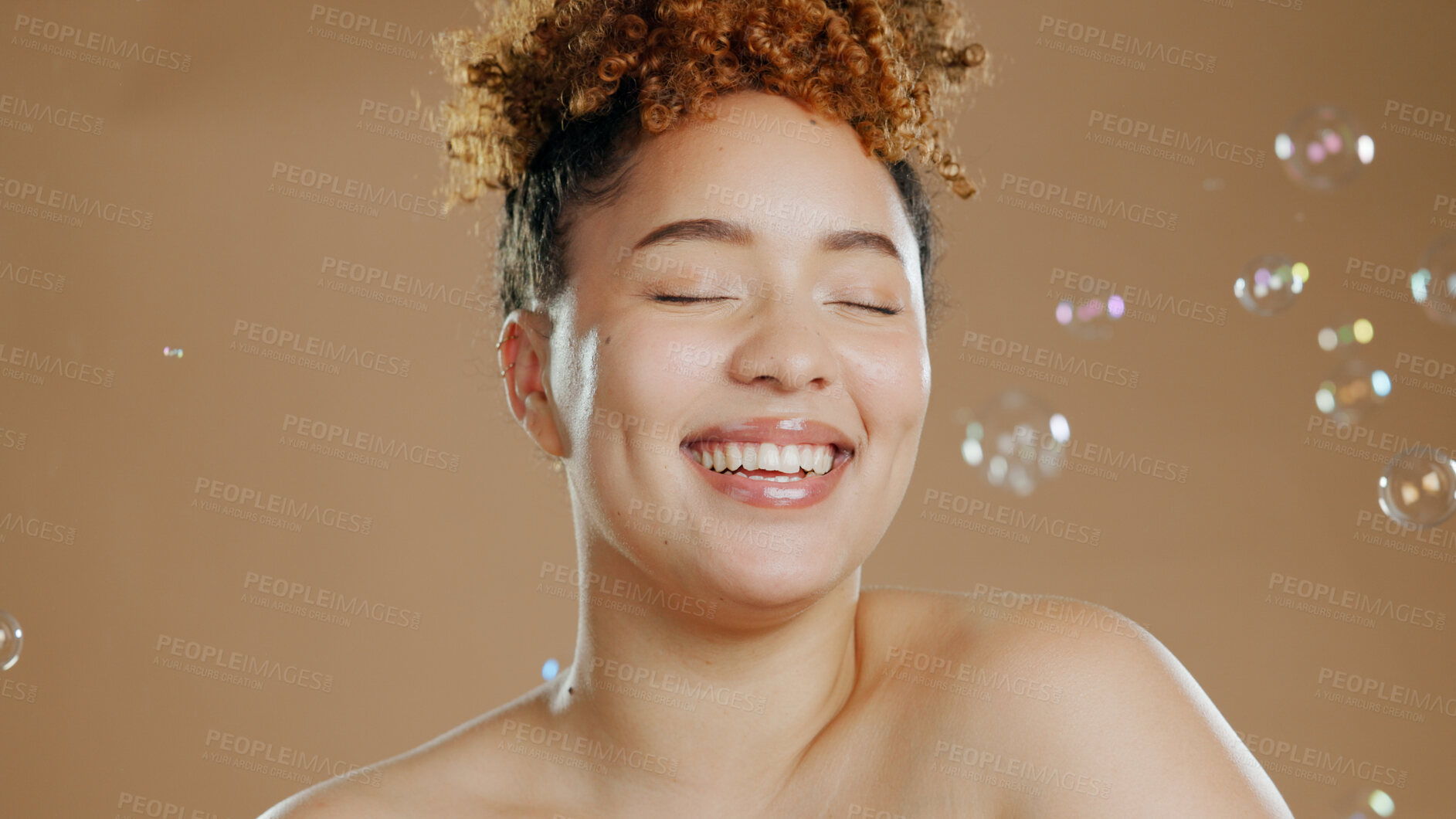 Buy stock photo Woman, bubbles and skincare for beauty, happy with natural cosmetics and glow isolated on brown background. Dermatology, wellness for skin and liquid soap with self care and anti aging in studio