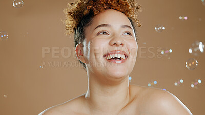 Buy stock photo Happy woman, bubbles and skin for beauty, happy with natural cosmetics and glow on brown background. Dermatology, wellness with skincare and liquid soap for self care and anti aging in studio