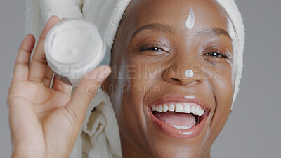 Buy stock photo Woman, moisturizer and smile in portrait for skincare or beauty, health and wellness or dermatology. Happy black person, skin and cosmetics, care and cream on face in studio by gray background