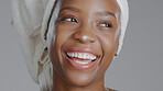 Face, beauty and lotion with a happy black woman in studio on a gray background for natural wellness. Skincare, smile and cream with a happy young model closeup to apply treatment to her skin
