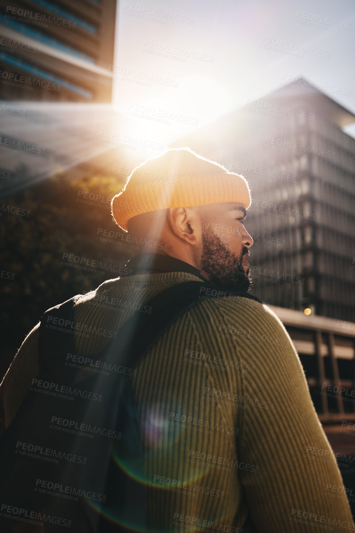 Buy stock photo Back, thinking and man in a city, fashion and lens flare with ideas, planning and decision. Person, gen z and guy outdoor, sunshine and backpack with buildings, fashion and choice with casual outfit