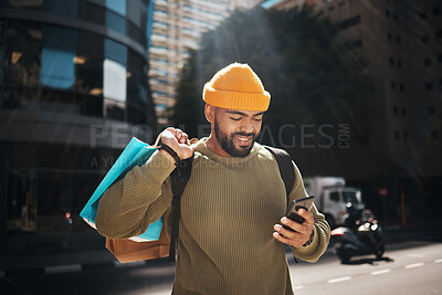 Buy stock photo Student, phone and shopping bag in city travel, walking and search for student deal, discount or online sale. Happy african man with retail gift and mobile app, social media and chat in urban street