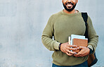 Happy man on wall background, university books and smile with mockup on campus for education with backpack. Learn, study and college student on grey space with information, knowledge and opportunity.