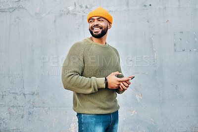 Buy stock photo Cellphone, happy and young man by wall networking on social media, mobile app or the internet. Technology, smile and male person from Colombia scroll on website with phone in city by gray background.