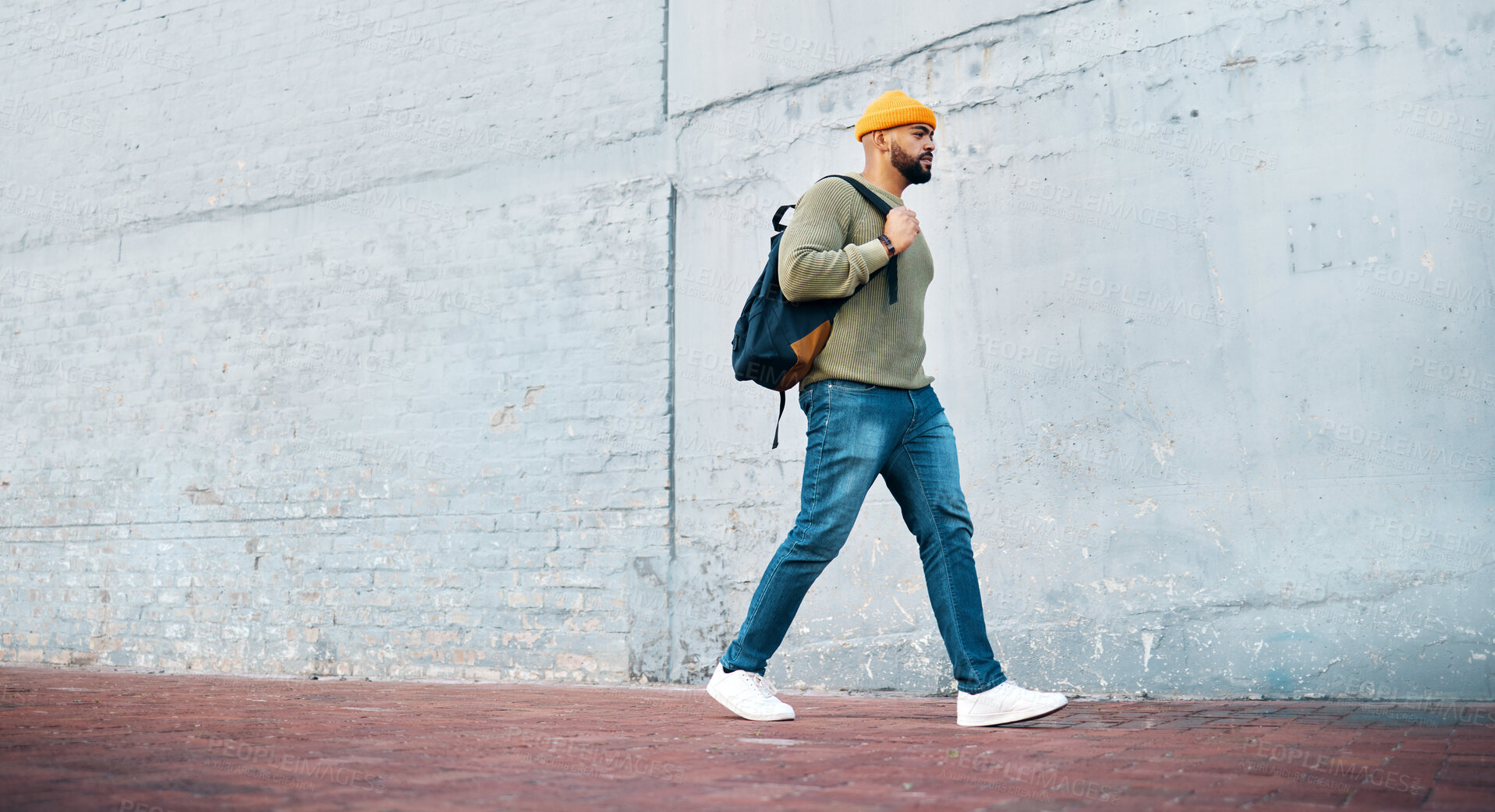 Buy stock photo Man, walking and travel with student on wall, mockup and space in urban, campus or street in town. University, person and commute on path, road or journey to college in city with backpack