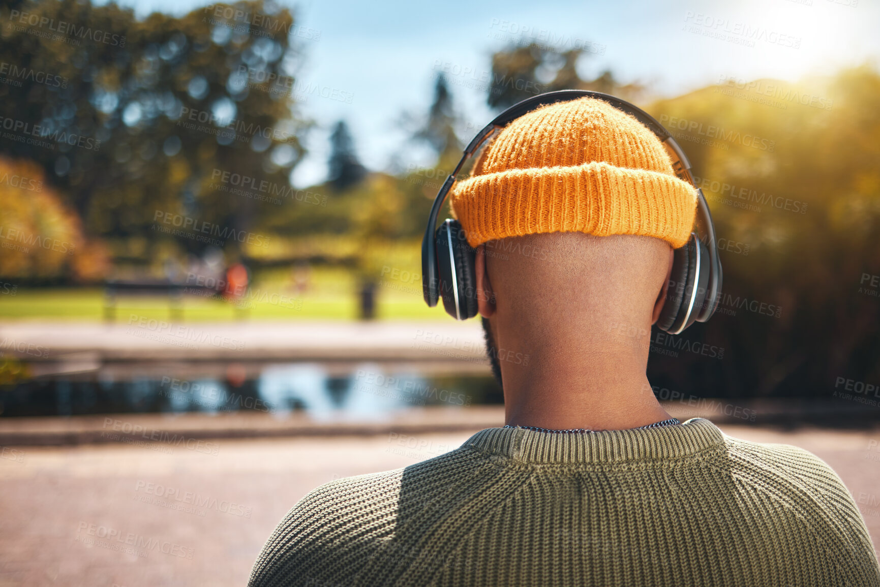 Buy stock photo Back view, music headphones and man outdoor, listen to audio or streaming sound online. Radio, podcast and person at park in nature, garden and hearing media, jazz or hip hop on internet for freedom