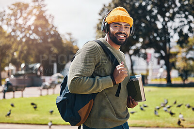 Buy stock photo Student, headphones and backpack for outdoor education, college or university podcast in park or campus. Portrait of african man walking, travel and books with study, learning and listening to music