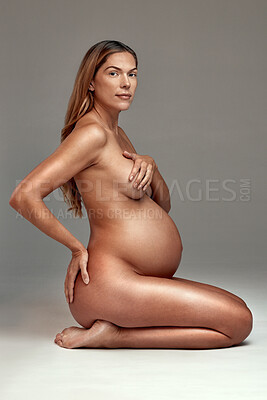 Buy stock photo Portrait, nude and beauty with a woman pregnant in studio on a gray background as a mother or parent. Aesthetic, skin or wellness and the body, stomach or belly of a young person for pregnancy growth