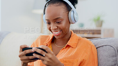 Buy stock photo Phone games, headphones and woman in home on sofa for playing online gaming, podcast subscription or connection. Happy african person, video game or smartphone in living room for streaming multimedia