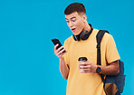 Student, winner and man wow for phone news, college results or scholarship success on a blue background. Young person reading notification, winning and social media on mobile with surprise in studio