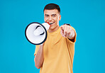 Bullhorn, happy and portrait of man in studio pointing for announcement, speech or rally. Smile, protest and young person from Canada with megaphone for loud communication isolated by blue background