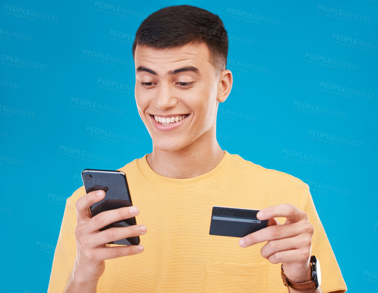 Buy stock photo Credit card, ecommerce and man with a smartphone, payment and transaction on a blue background. Person, guy and happy model with a cellphone, digital app and online banking with finance and savings