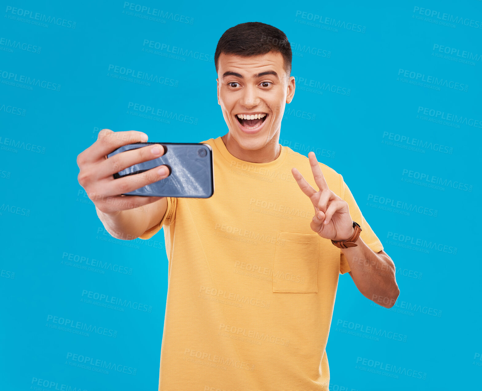 Buy stock photo Man, selfie and peace hand sign with happiness, excited with social media with communication on blue background. V emoji, influencer with memory and smile in picture with photography in a studio