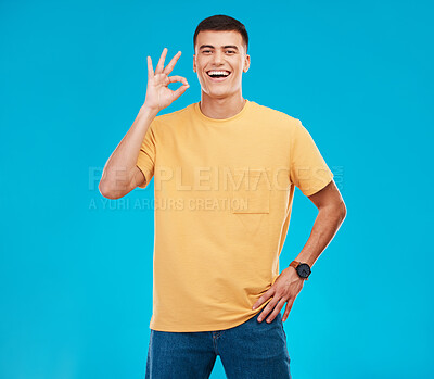 Buy stock photo Pefect sign, happy and portrait of a man on a blue background for a review, feedback or emoji icon. Happy, agreement and a person with a gesture in studio for success, opinion or ok approval