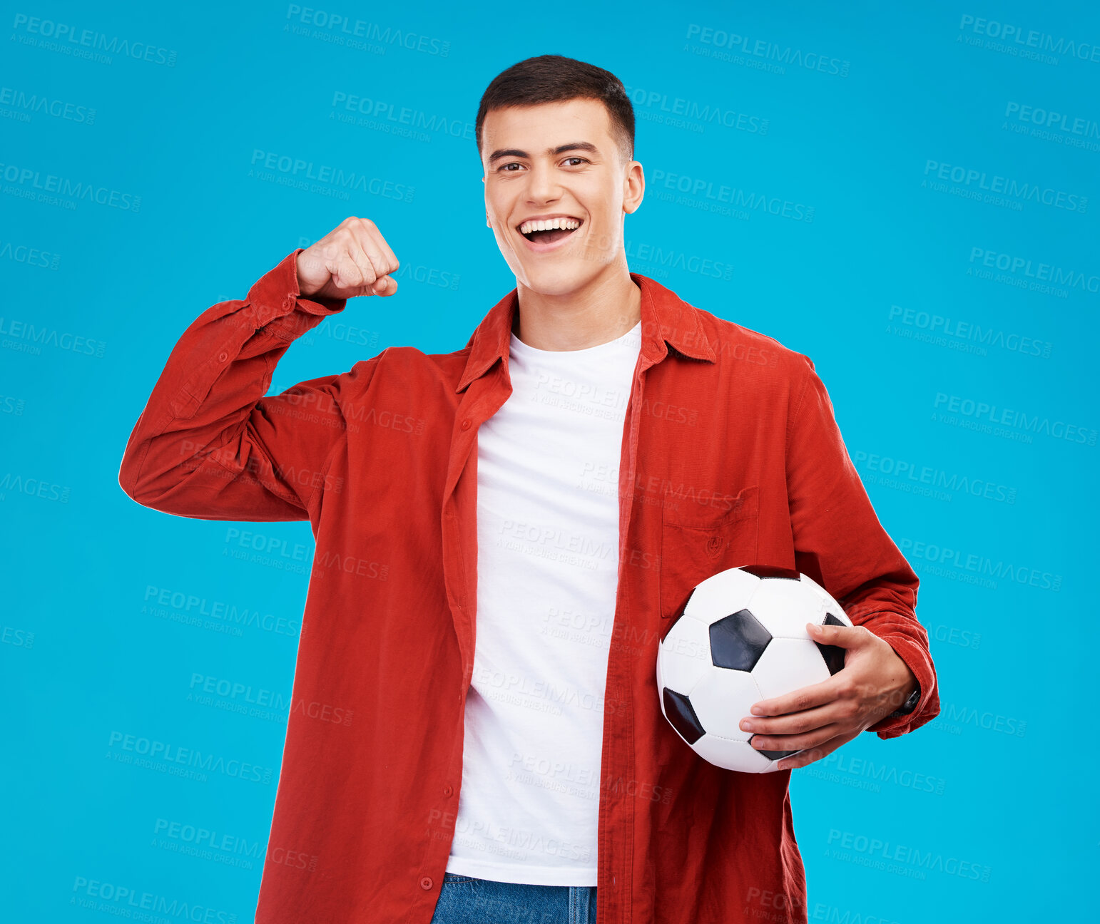 Buy stock photo Portrait, football and happy man with strong muscle in studio isolated on a blue background. Face, soccer and excited person flex bicep for power, sports and success in competition, winner or fitness