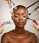 Makeup, brushes and black woman with cosmetics, skincare and dermatology on grey studio background. African person, wellness or model with tools, grooming and treatment with luxury or shine with glow
