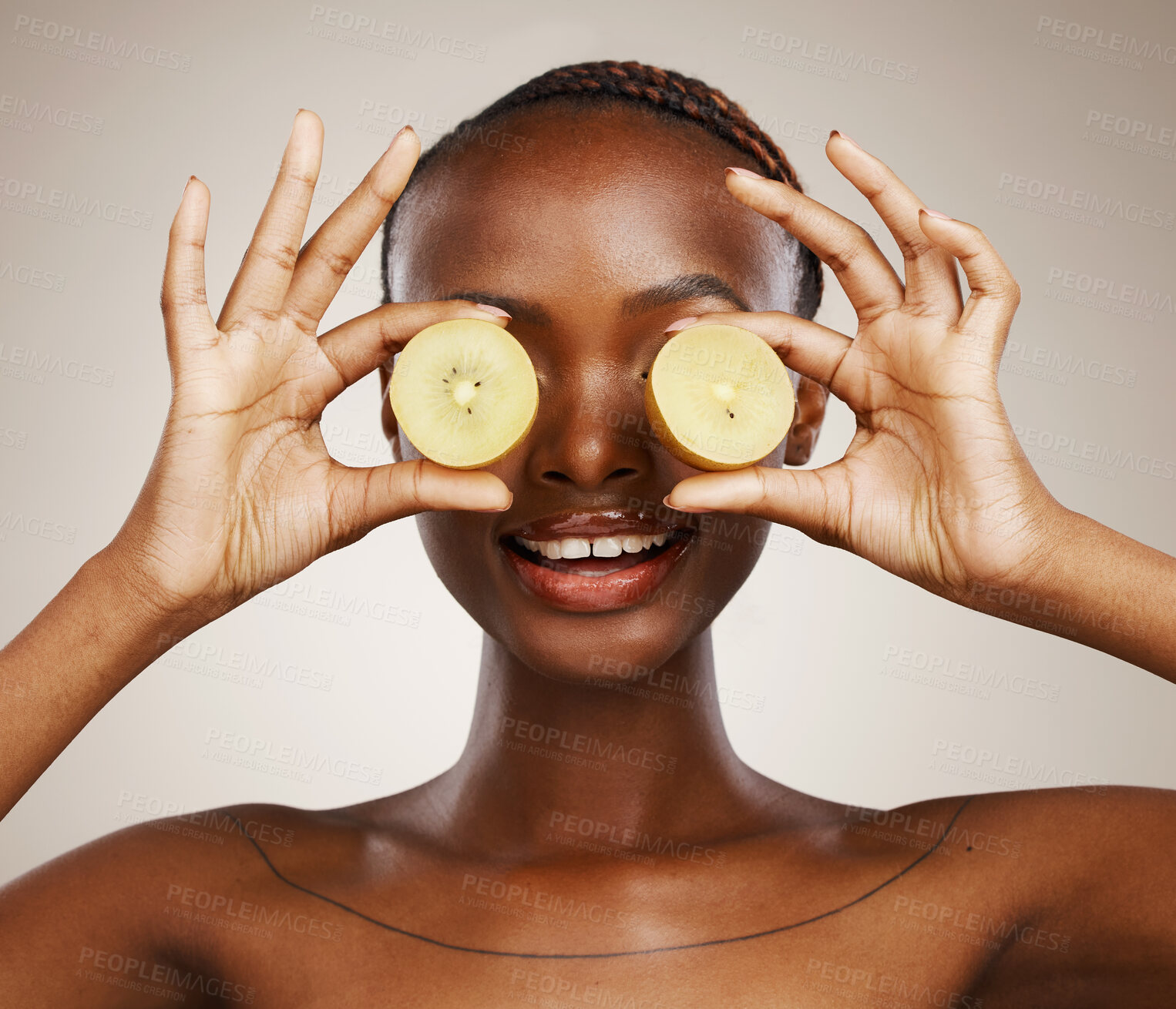 Buy stock photo Kiwi, wellness and a black woman on a studio background for skincare, dermatology and a glow. Nutrition, hands and an African person or model with fruit for health, diet food and an organic snack