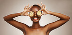 Kiwi, smile and a black woman on a studio background for nutrition, dermatology and a glow. Happy, hands and an African person or model with fruit for health, diet and an organic snack for vitamin c