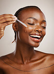 Happy woman, skincare and serum on face in studio for beauty, dermatology or collagen on brown background. African model, facial cosmetics and liquid dropper of hyaluronic acid, essential oil or glow