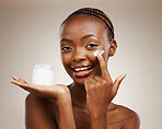 Portrait of black woman, happy or cream for wellness in studio with smile, natural cosmetics or glow. Dermatology, face or African girl model applying skincare lotion or creme on brown background 