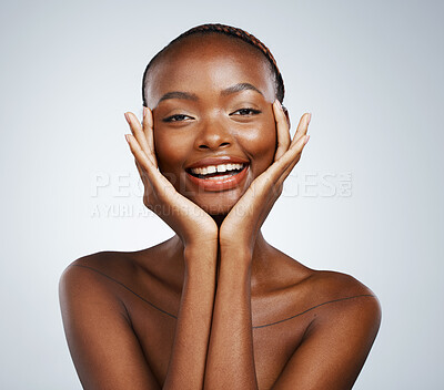 Buy stock photo Portrait, beauty and hands on the cheek of a black woman in studio on a gray background for skincare or natural wellness. Smile, spa or luxury and a young model with cosmetic or antiaging treatment