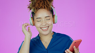 Buy stock photo Headphones, music and woman with phone in studio listening to song, audio and radio. Happy, smile and face of person with smartphone for streaming subscription, relax and fun on purple background