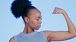 Black woman, flexing bicep for power and champion in studio, strong with muscle on blue background. Competition, contest and winner with fist, strength and bodybuilder with empowerment and pride