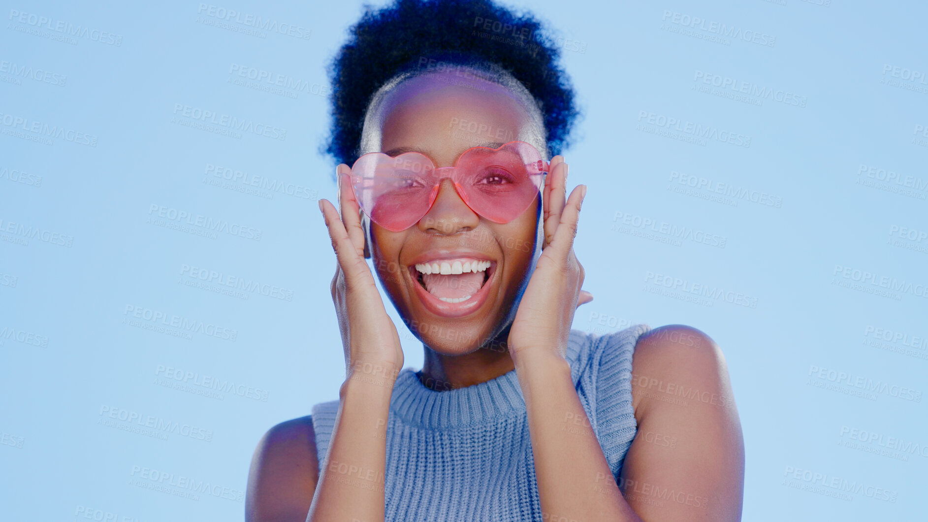 Buy stock photo Black woman, happiness in portrait and heart sunglasses, funky accessory with fun isolated on blue background. Shades, protection and eye care with party, fashion and vision with energy in studio