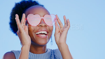 Buy stock photo Fashion, sunglasses and smile, black woman in studio with cool, trendy summer style and creative mockup. Happiness, luxury eyewear and excited, fun model with designer frame on blue background space