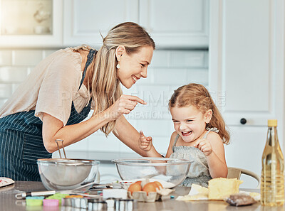 Buy stock photo Mom, girl kid and teaching for baking, development and laugh with bonding, love and care in family home. Cooking, funny mother and daughter with bowl, flour or eggs on table, kitchen or help for food