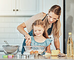 Mom, girl child and learning with whisk, development and skills with bonding, love or care in family house. Cooking, mother and daughter with smile, flour and eggs on table, kitchen and help for food