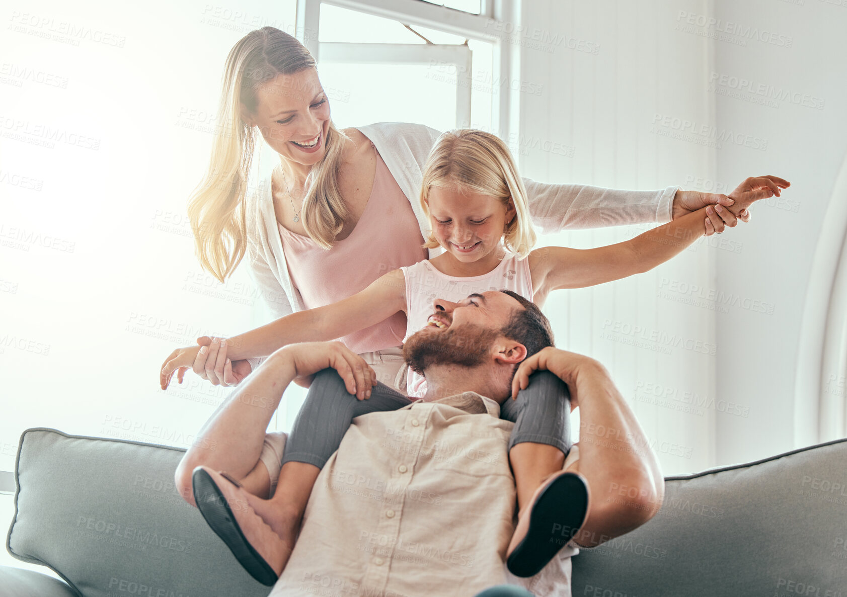 Buy stock photo Parents, kid and airplane on couch, smile and playful for love, care or bonding in living room at family home. Father, mother and daughter with plane game, excited and relax on lounge sofa in house