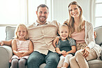 Happy family, portrait and relax on living room sofa for bonding, weekend or holiday together at home. Mother, father and children smile, hug and sitting on couch for summer break or rest at house