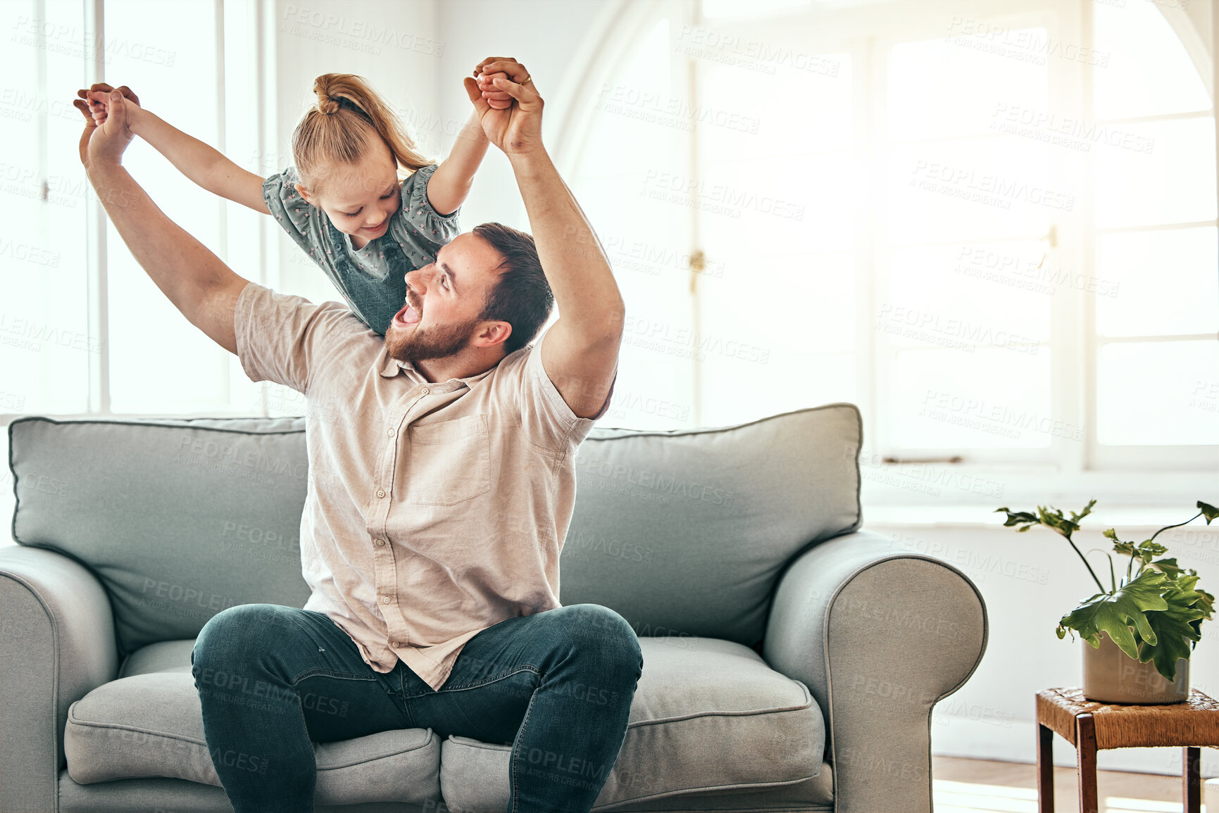 Buy stock photo Father, girl kid and airplane on sofa, smile and playful for love, care and bonding in living room at family home. Dad, daughter and plane game, excited and relax together on lounge couch in house