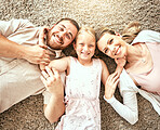 Happy, portrait and kid with parents in the living room bonding and relaxing together at home. Happiness, love and girl child laying with mother and father from Australia on floor in lounge at house.