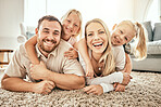 Happy, smile and portrait of family in the living room bonding, hugging and relaxing together. Happiness, love and girl children laying with parents from Australia on floor in lounge at modern home.