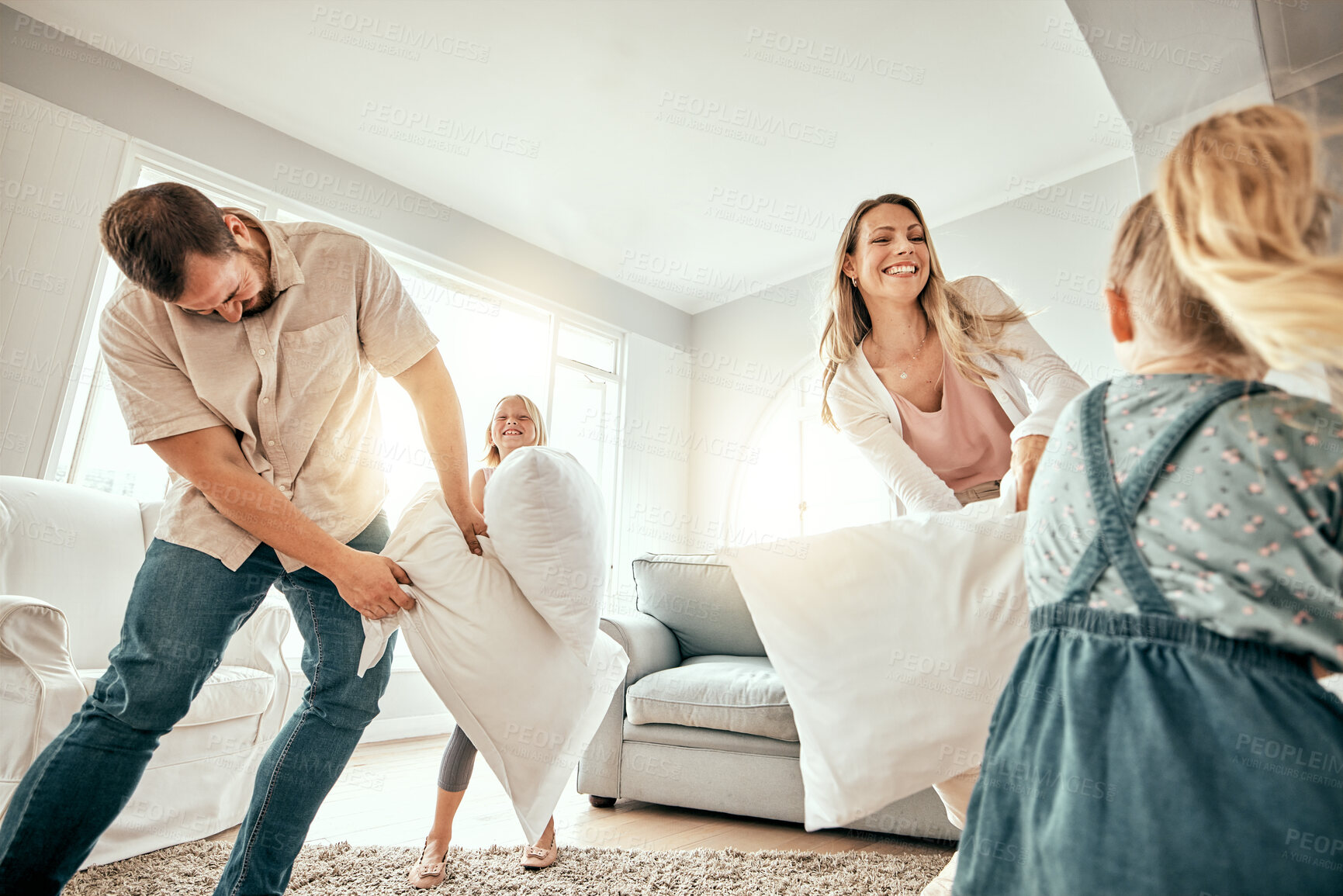 Buy stock photo Happy family, pillow fight and playing in living room for fun bonding, holiday or weekend together at home. Mother, father and children smile with cushion game, play or free time for summer break