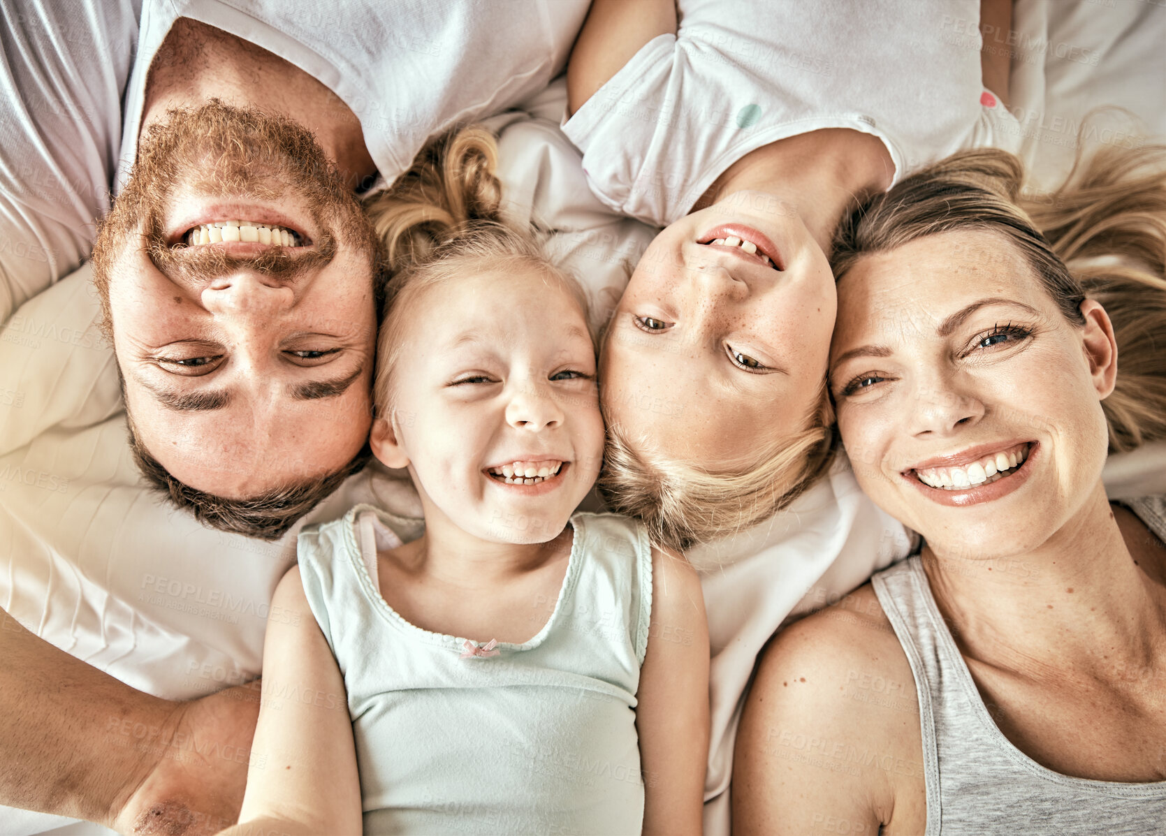 Buy stock photo Happy, smile and portrait of family on a bed for bonding and relaxing together at modern home. Happiness, love and top view of girl children laying with parents from Australia in bedroom at house.