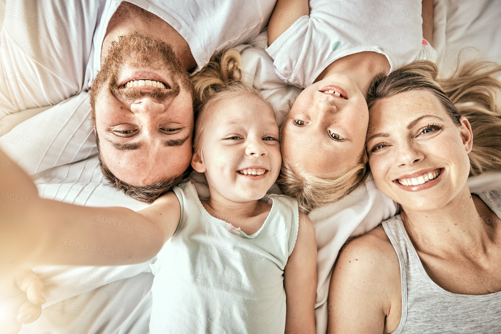 Buy stock photo Happy, love and portrait of family on a bed for bonding and relaxing together at modern home. Happiness, smile and top view of girl children lying with parents from Australia in bedroom at house.