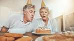 Blowing candles, senior couple and cake for a birthday, celebration party or eating together. Wish, house and an elderly man and woman with sweet food or hungry for a snack together for anniversary