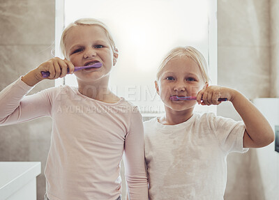 Buy stock photo Children, brushing teeth and a girl with her sister in the bathroom of their home together for oral hygiene. Portrait, dental cleaning and siblings using a toothbrush in the morning for mouth care