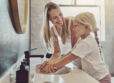 Buy stock photo Bathroom, mother and child washing hands with water, soap and learning healthy hygiene together. Cleaning dirt, germs or bacteria on fingers, mom and girl in home for morning wellness, help and care.