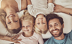 Happy family, portrait and lying in bed above for weekend, holiday or wake up together at home. Top view and faces of mother, father and children smile in bedroom happiness, quality time or bonding