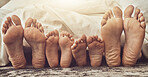 Feet, love and family in bed together to relax on a weekend morning in their home with flare. Mother, father and children with blankets sleeping in the bedroom to rest while dreaming closeup