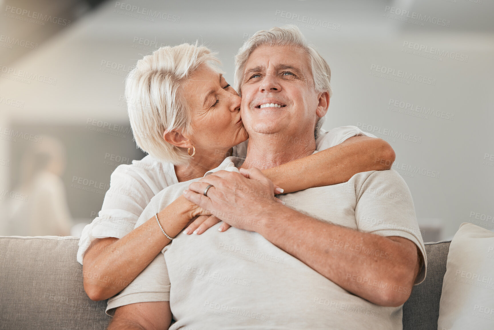 Buy stock photo Happy senior couple, kiss and hug on sofa in living room for embrace, love or affection at home. Mature woman kissing and hugging man with smile in care, trust or support on lounge couch in house