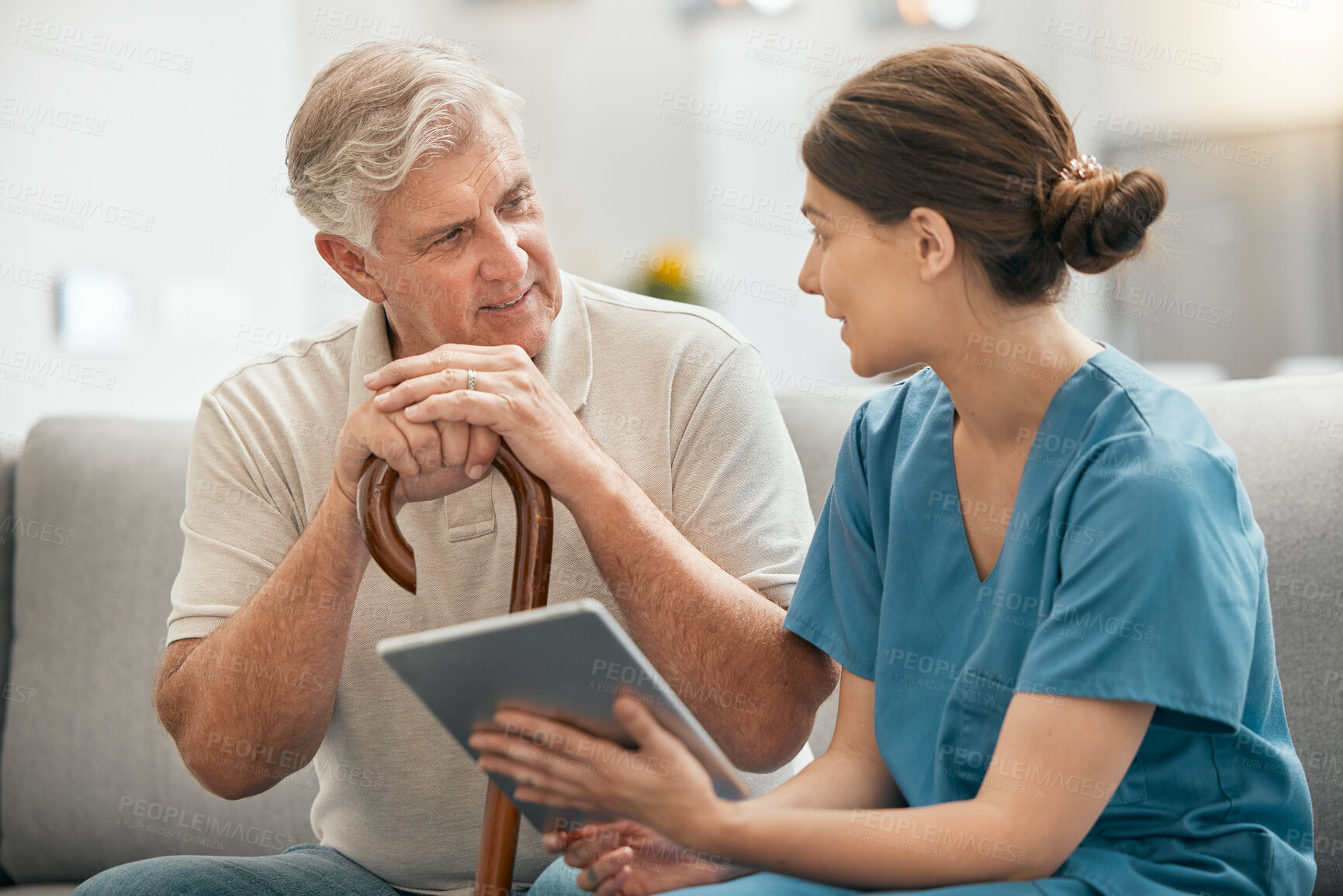 Buy stock photo Woman, nurse and tablet in elderly care, consultation or visit in retirement home for healthcare advice. Female person or medical caregiver talking to retired man or patient with technology on sofa